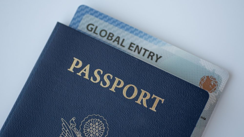 Global Entry card (Trusted traveller) covered of Passport of United states on white background.